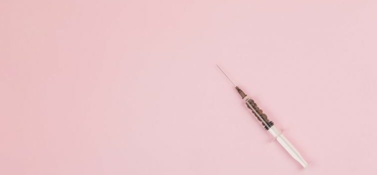 Botox nål med lyserød baggrund